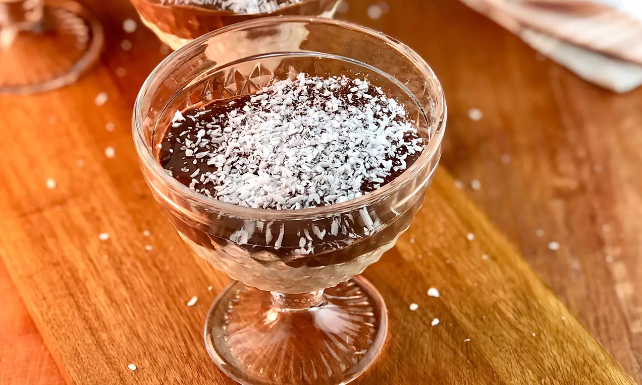 Pavê de chocolate e coco sem açúcar com camadas de creme branco e ganache escura, raspas de coco e folhas de hortelã